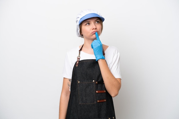 Fishmonger woman wearing an apron having doubts while looking up