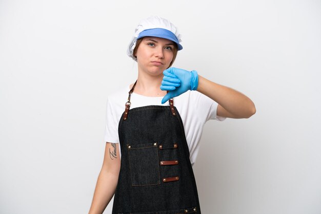 Fishmonger woman wearing an apron showing thumb down with negative expression