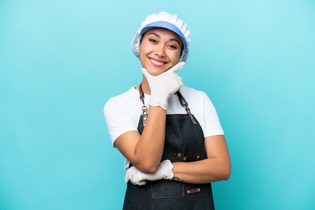 Fishwife argentinian woman isolated on blue background happy
and smiling