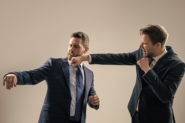 Фото Кулак в лицо, коллеги разногласий конфликтуют, бизнесмены бьют кулаками в драке