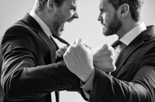 Photo fist of punching disagreed men business partners or colleague disputing selective focus corporate battle