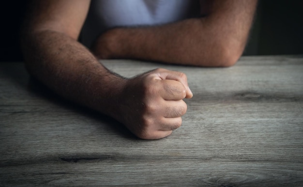 Fists of angry man beats on the table