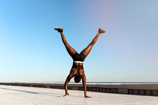 Fit atletische vrouw doet hand staande op het strand