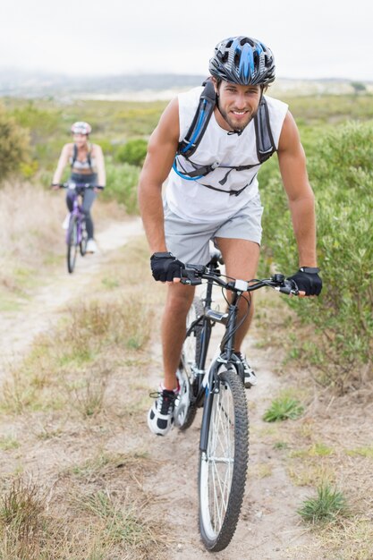 Fit attractive couple cycling on mountain trail