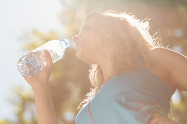 彼女の水のボトルからぴったりのブロンドの飲み物