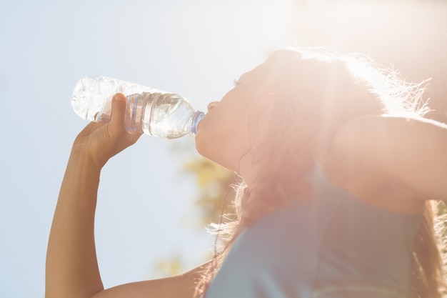 彼女の水のボトルからぴったりのブロンドの飲み物