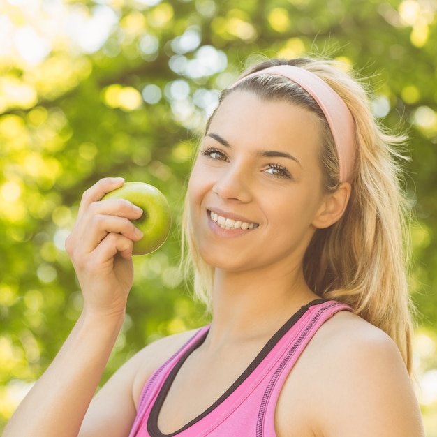 Fit blonde holding green apple