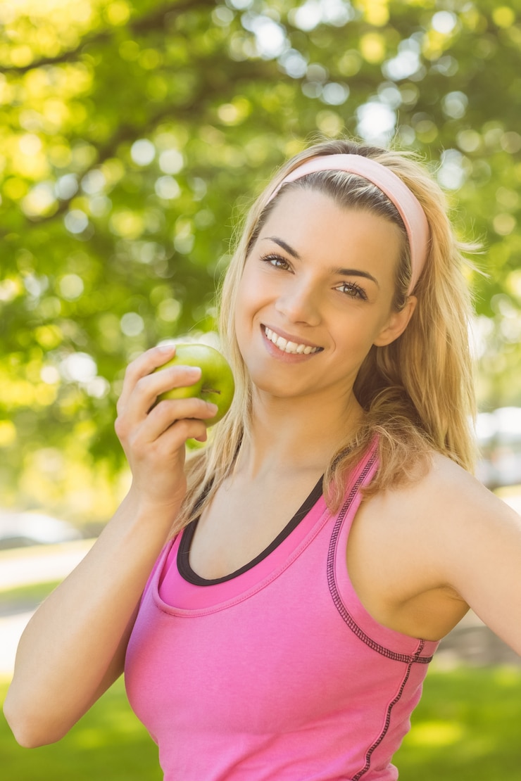 Photo fit blonde holding green apple