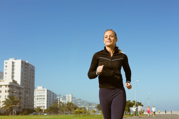 Fit blonde joggen op de pier