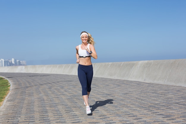 Fit blonde jogging on the pier