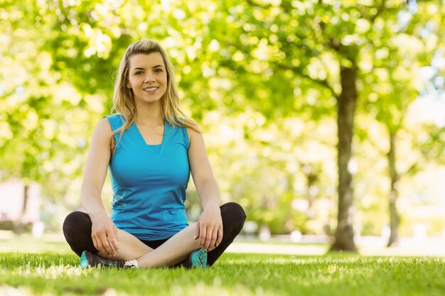 Fit blonde sitting on the grass