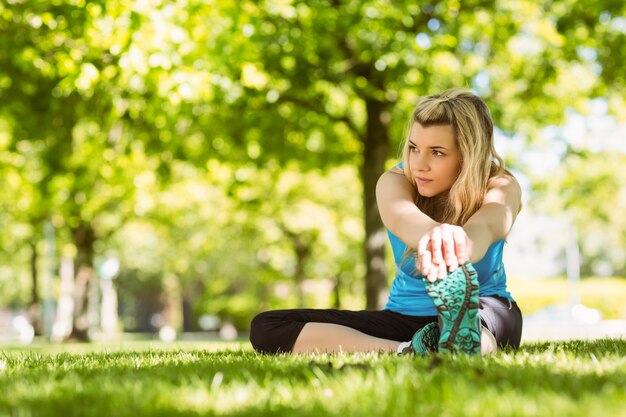 Fit blonde stretching on the grass