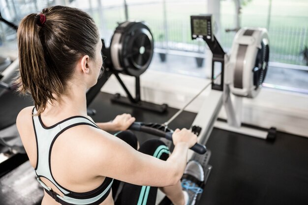 Fit brunette op tekenmachine in de sportschool