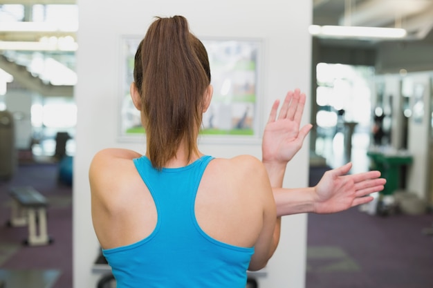 Fit brunette warming-up in de fitness-studio