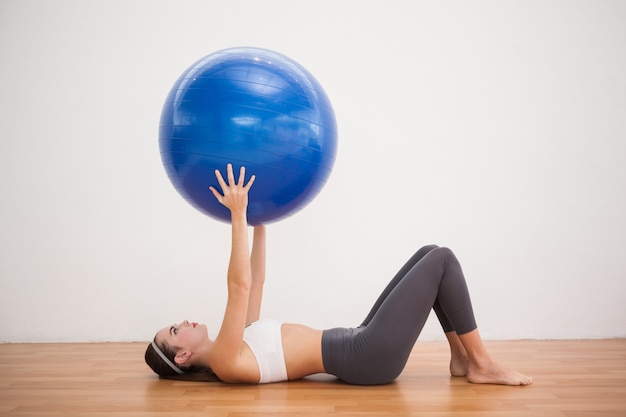 Photo fit brunette working out with exercise ball