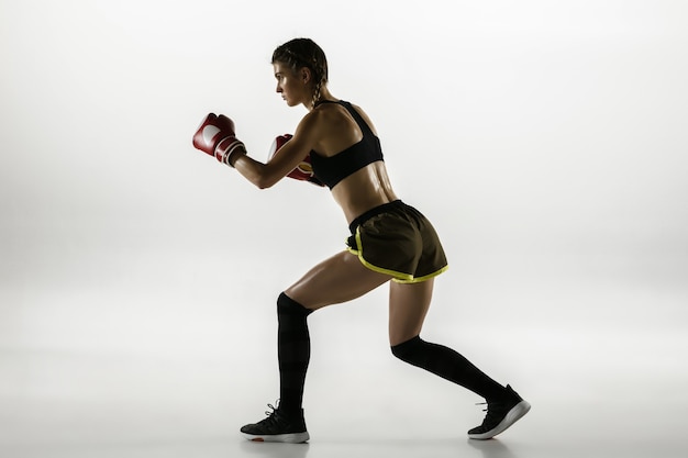 Fit caucasian woman in sportswear boxing isolated on white studio background