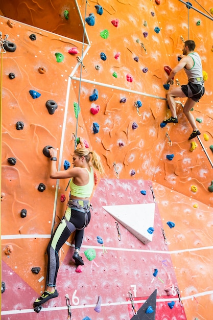 Fit couple rock climbing indoors 