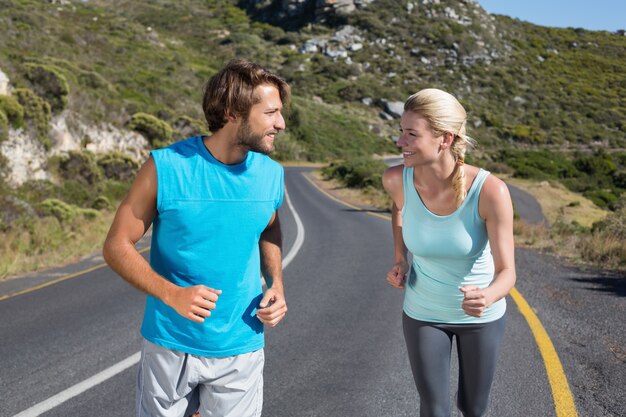 Fit couple running together up a road