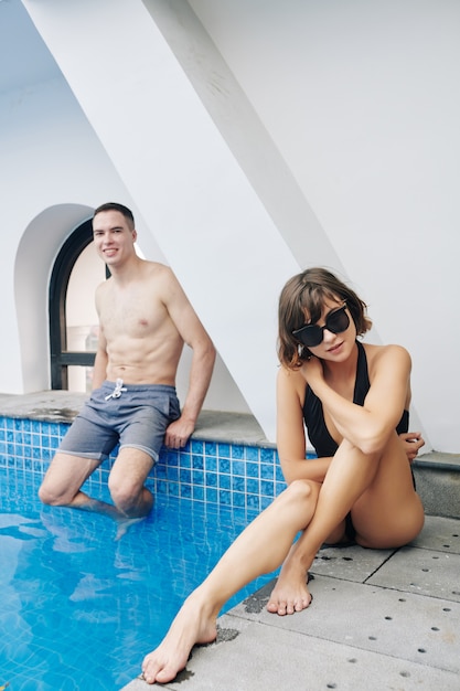 Fit couple sitting at swimming pool