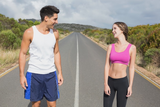 Fit couple standing on the open road