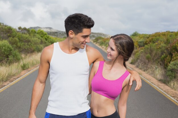 Fit couple standing on the open road