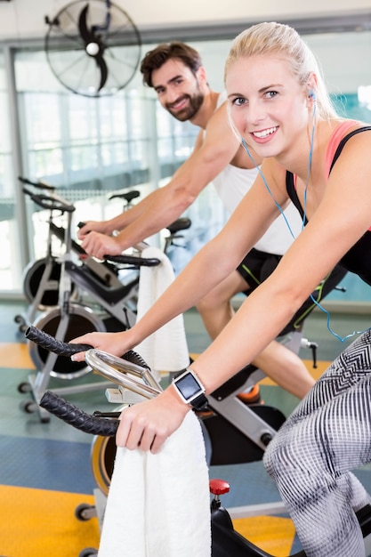 Fit couple using exercise bikes at the gym