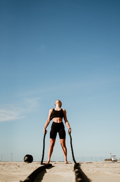 Fit en afgezwakt Sportvrouw trainen in functionele training sportschool op het strand