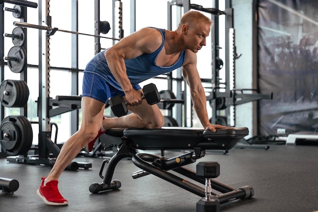 Fit en gespierde man traint met halters