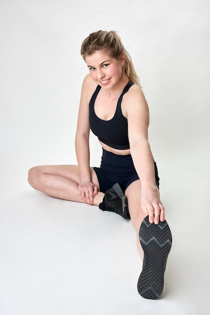 Fit female model stretching on studio floor
