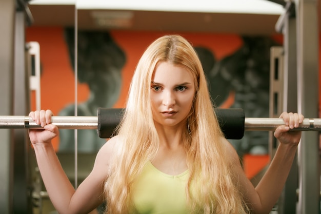 Fit girl doing lunges with the smith machine