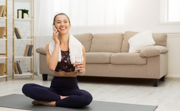 Fit Girl Refreshing With Water And Talking On Phone