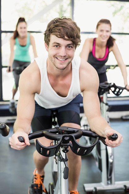 Fit groep mensen met behulp van hometrainer samen op gymnasium