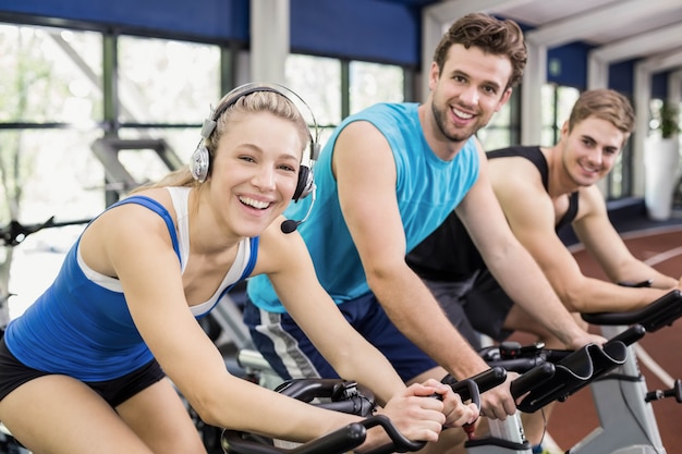 Fit group of people using exercise bike together at gym