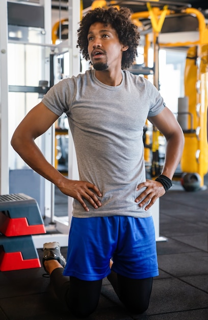 Fit handsome man exercising at the gym on a machine