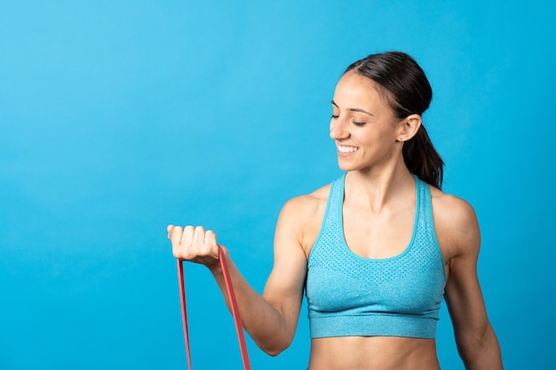 Fit hispanic woman using rubber pilates gum