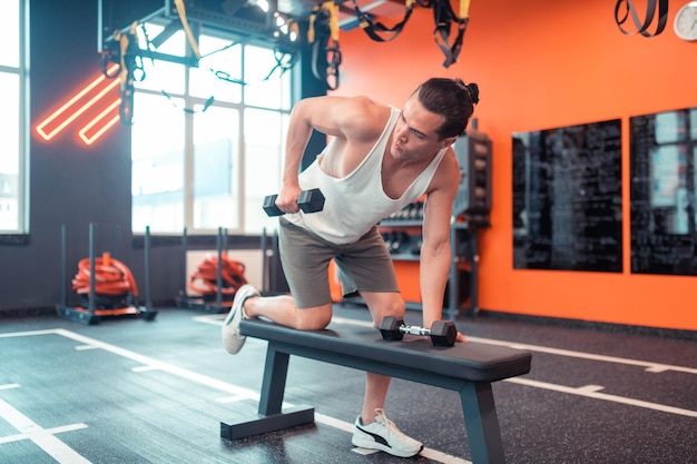 Fit jonge man trainen met twee halters