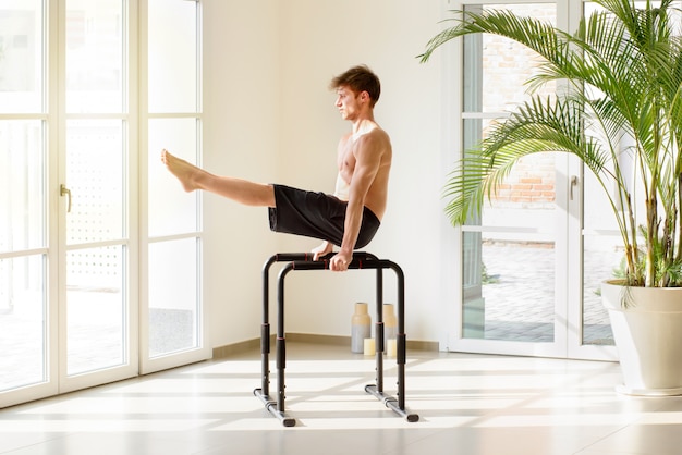 Fit jonge man uit te werken op parallelle staven