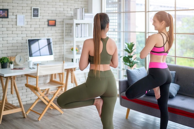 Fit jonge vriend vrouwen doen yoga en meditatie thuis sport en gezonde levensstijl concept