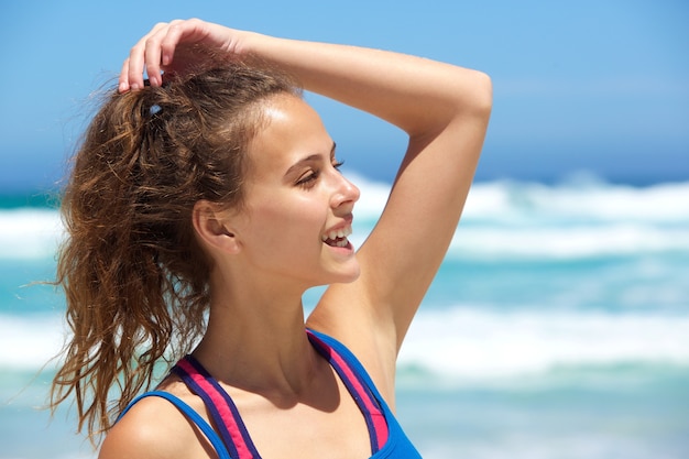 Fit jonge vrouw die lacht op het strand