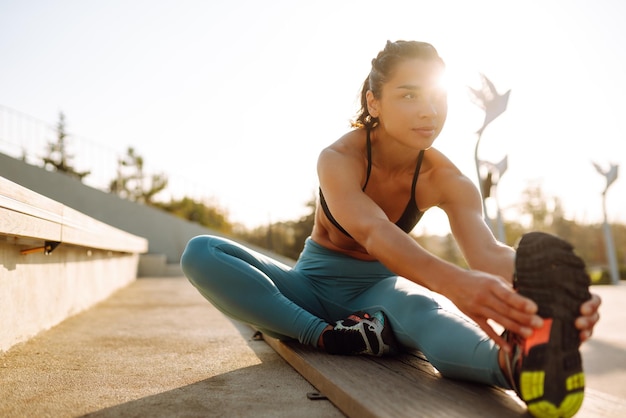 Fit Jonge vrouw in sportkleding doet yoga fitness oefening op straat Sport Actief leven
