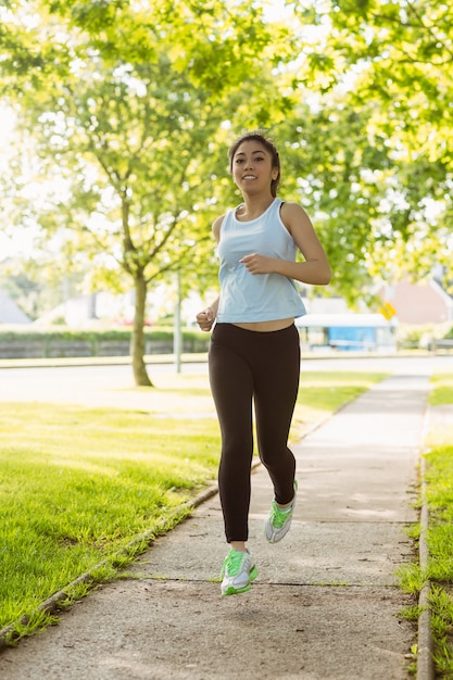 Fit jonge vrouw joggen door het park