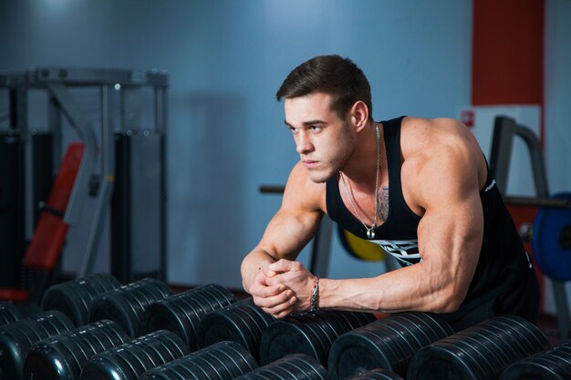 Fit male athlete getting ready for dumbbell workout