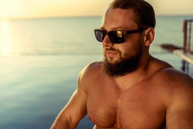 Fit man bodybuilder coming out of pool