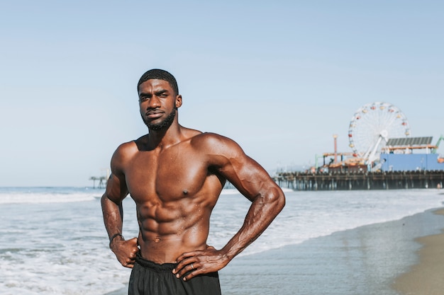 Fit man die zich voordeed op het strand