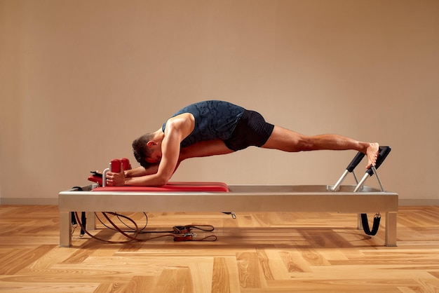 Foto fit man doet een lunge stretch yoga pilates oefening om zijn spieren te versterken en te tonen met behulp van een