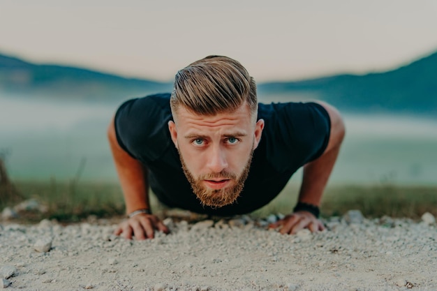 Fit man doet push ups oefening op outdoor sportschool. Core body workout atleet planking of push-up op gras.