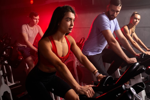 Fit man en vrouw in de sportschool, perfect gevormde gespierde mensen trainen op de fiets, cardiotraining bij fitness gym, gewichtsverlies met machine nemen