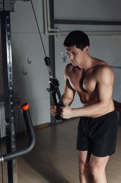 Fit man exercising at the gym on a machine.