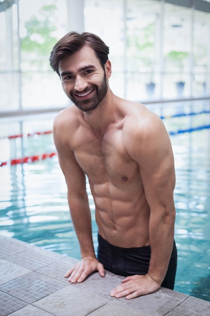 Fit man getting out of the water at the pool