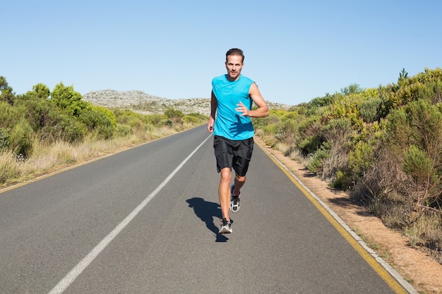 Fit man jogging on the open road